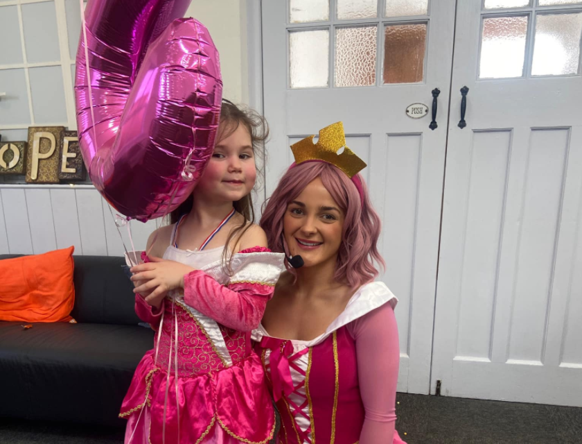 Party entertainer and child at a princess themed party