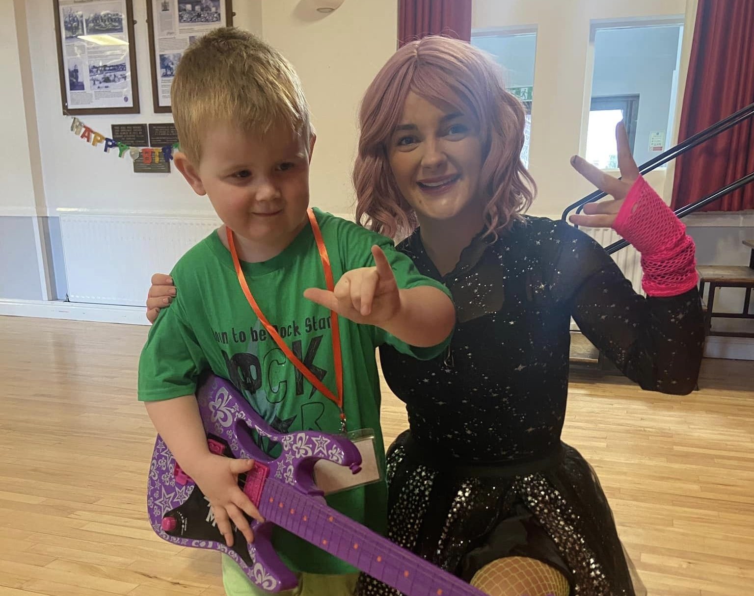 Party entertainer and child at a rockstar themed party